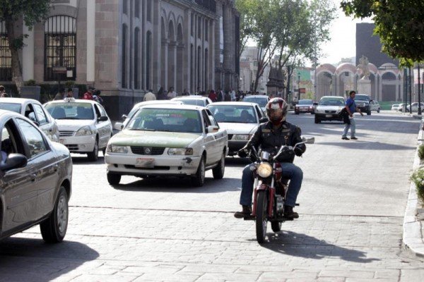 MOTOCICLISTA CIRCULA ENTRE AUTOS